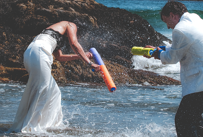 a married couple playing with water guns